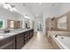 Spacious main bathroom features a long granite countertop with double sinks, a shower, and a soaking tub at 4425 Martel Dr, Cumming, GA 30040
