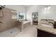 The main bathroom has double sinks, a glass shower and a large tub with natural light from the window at 4425 Martel Dr, Cumming, GA 30040