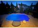 Large in-ground pool surrounded by lush landscaping illuminated at dusk at 4425 Martel Dr, Cumming, GA 30040