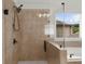 Modern walk-in shower features a frameless glass enclosure, contemporary fixtures, and natural light from the window at 4425 Martel Dr, Cumming, GA 30040