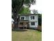 Beautiful two-story home with a welcoming front porch, mature trees, and fenced yard at 1962 Compton Se Dr, Atlanta, GA 30315