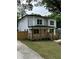 Beautiful two-story home with a wooden porch, fenced yard, and lush green lawn at 1962 Compton Se Dr, Atlanta, GA 30315