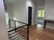 Hallway featuring gleaming hardwood floors and an eye-catching modern black iron railing at 1962 Compton Se Dr, Atlanta, GA 30315