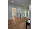 Hallway featuring gleaming hardwood floors and an eye-catching modern black iron railing at 1962 Compton Se Dr, Atlanta, GA 30315