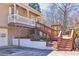 Home exterior showcasing a side entrance with a wooden staircase and landscaped garden at 3016 Ansley Manor Ct, Snellville, GA 30078