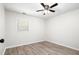 Cozy bedroom with neutral walls, wood-look flooring, a ceiling fan, and a window offering natural light at 6658 Collins Ct, Riverdale, GA 30274