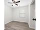 This bedroom features wood-look flooring, a ceiling fan, a closet, and a window for natural light at 6658 Collins Ct, Riverdale, GA 30274