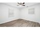 Bright bedroom with wood-look floors, two windows allowing ample natural light, and a ceiling fan at 6658 Collins Ct, Riverdale, GA 30274