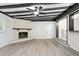 Spacious living room with wood-look flooring, stone fireplace, and exposed beamed ceilings at 6658 Collins Ct, Riverdale, GA 30274