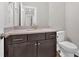 Bathroom featuring dark cabinets, a granite countertop, toilet, and framed mirror at 1065 Low Water Crossing Nw, Acworth, GA 30101