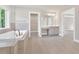 Bright bathroom with soaking tub, glass shower, double sink vanity, walk-in closet, and neutral color palette at 1065 Low Water Crossing Nw, Acworth, GA 30101