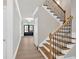 Entry hallway features light hardwood floors and staircase with wood and black iron railing at 1065 Low Water Crossing Nw, Acworth, GA 30101