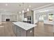 Kitchen island boasts quartz countertops, gray cabinets, stainless appliances, and open access to other rooms at 1065 Low Water Crossing Nw, Acworth, GA 30101