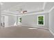 Main bedroom with a tray ceiling, two windows and neutral carpet at 1065 Low Water Crossing Nw, Acworth, GA 30101