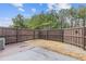 Fenced backyard with a wood deck, gravel area, and some mature trees at 2183 Miranda Dr, Morrow, GA 30260
