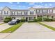 Attractive townhome featuring attached garage, covered porch, manicured lawn, and mature trees at 2183 Miranda Dr, Morrow, GA 30260