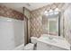 Well-lit bathroom featuring a tub, a toilet, a sink and unique tile and wall paper patterns at 245 River Laurel Way, Woodstock, GA 30188