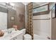 Cozy bathroom with shower-tub combo, decorative wallpaper, and bright lighting at 245 River Laurel Way, Woodstock, GA 30188