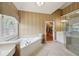 Bright bathroom featuring a soaking tub, vanity with sink, and glass shower stall at 245 River Laurel Way, Woodstock, GA 30188