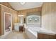 Bright bathroom featuring a soaking tub, vanity with sink, and decorative window at 245 River Laurel Way, Woodstock, GA 30188