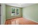 Bright bedroom with hardwood floors and a large window offering natural light and view of outside greenery at 245 River Laurel Way, Woodstock, GA 30188