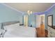 Bedroom with a chandelier, hardwood floors, and blue accent lighting at 245 River Laurel Way, Woodstock, GA 30188