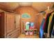 Cozy attic closet with unique window, cabinet, and clothes rack at 245 River Laurel Way, Woodstock, GA 30188