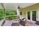 Cozy covered deck with seating, a ceiling fan, and a view of the surrounding greenery at 245 River Laurel Way, Woodstock, GA 30188