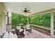 Relaxing deck area with ceiling fan, offering a peaceful outdoor space for entertaining with wooded views at 245 River Laurel Way, Woodstock, GA 30188