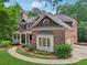 A beautiful brick home with a charming front porch, bay window, and well-manicured lawn at 245 River Laurel Way, Woodstock, GA 30188