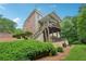 Backyard view of a two story traditional brick home with wooden deck at 245 River Laurel Way, Woodstock, GA 30188