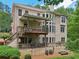 Back of home with large windows, an elevated deck, and a stone patio at 245 River Laurel Way, Woodstock, GA 30188