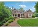 Classic brick home with a covered front porch, manicured lawn, and mature landscaping at 245 River Laurel Way, Woodstock, GA 30188