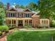 Beautiful two-story brick house boasts a lush green lawn and a charming covered front porch at 245 River Laurel Way, Woodstock, GA 30188
