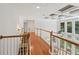 Hallway with a wooden handrail and hardwood floor, leading into a large living room at 245 River Laurel Way, Woodstock, GA 30188