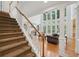 Bright living room with large windows, hardwood floors, and detailed trim opens to the upper level via the staircase at 245 River Laurel Way, Woodstock, GA 30188