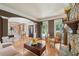 Charming living room offers a stone fireplace, hardwood floors, natural light, and an open view to the foyer at 245 River Laurel Way, Woodstock, GA 30188