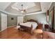 Charming primary bedroom showcasing hardwood floors, a ceiling fan, a bench, and large dresser at 245 River Laurel Way, Woodstock, GA 30188