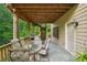 Covered patio features a dining table, outdoor kitchen, and durable flooring, perfect for outdoor entertaining at 245 River Laurel Way, Woodstock, GA 30188