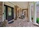 Inviting brick porch with stately columns and decorative lion statues flanking the glass-paneled front door at 245 River Laurel Way, Woodstock, GA 30188