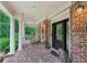 Elegant covered porch with brick flooring, white columns, and stately lion statues at 245 River Laurel Way, Woodstock, GA 30188