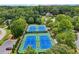 Aerial view of tennis courts in a lush, green community with mature trees, and ample parking at 245 River Laurel Way, Woodstock, GA 30188