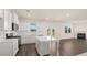 Bright kitchen featuring white cabinets, stainless steel appliances, center island, and seamless flow to the living area at 2939 Champions Way, Loganville, GA 30052