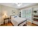 Bedroom features hardwood flooring, white bedding, and built-in shelving at 4075 Hickory Fairway Dr, Woodstock, GA 30188