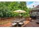 Inviting backyard deck featuring an umbrella-covered dining set and wooded views at 4075 Hickory Fairway Dr, Woodstock, GA 30188