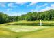 Scenic view of a lush green golf course with a pond and water fountain feature at 4075 Hickory Fairway Dr, Woodstock, GA 30188
