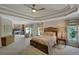 Spacious primary bedroom with tray ceilings, a fireplace, and lots of natural light at 4075 Hickory Fairway Dr, Woodstock, GA 30188