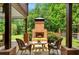 Outdoor patio features a brick fireplace, comfortable seating, and a view of the lush backyard at 4075 Hickory Fairway Dr, Woodstock, GA 30188