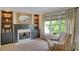 Cozy sitting room with a fireplace, built-in shelves, and large window with outdoor views at 4075 Hickory Fairway Dr, Woodstock, GA 30188