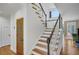Elegant staircase featuring hardwood steps, white risers, and a black handrail at 4075 Hickory Fairway Dr, Woodstock, GA 30188